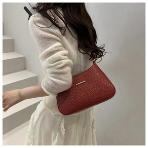 Close-up of wine red faux crocodile leather shoulder bag with gold metal trim