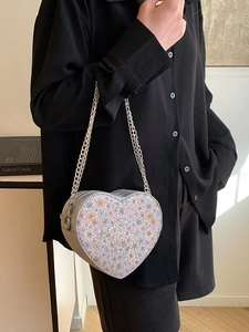 Fashionable heart-shaped sequin crossbody bag with colorful floral patterns and chain strap
