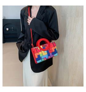 Detalle del asa circular roja y el bolso de mano con retazos geométricos de colores