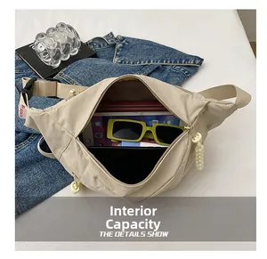 Internal view of beige nylon crossbody bag showing storage for phone and sunglasses