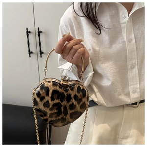 Detail of heart-shaped leopard print handbag with gold ring handle and chain strap