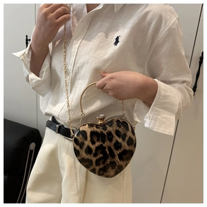 Detail of heart-shaped leopard print clutch with gold metal handle and crystal buckle