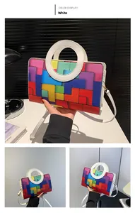 Detail of colorful geometric pattern handbag with white circular handle and shoulder strap