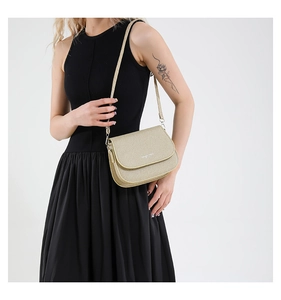 Detailed view of metallic gold saddle bag with glitter finish and fine shoulder strap