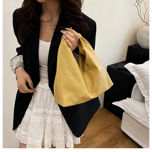 Détail d'un sac à main en similicuir jaune doux avec texture plissée minimaliste et drapé