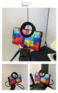 Detail of colorful geometric block pattern handbag with round handle and black strap