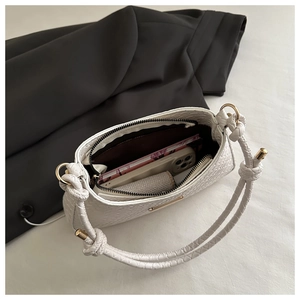 Interior view of white woven shoulder bag showing phone and card wallet storage