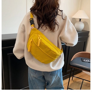 Detailed back view of a bright yellow nylon crossbody bag with adjustable strap
