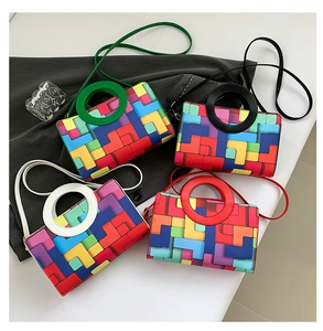 Detail view of colorful Tetris pattern handbags with large circular cutout handles and straps