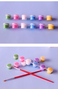 Close-up of 12-color acrylic paint pots and two red brushes for kids DIY painting
