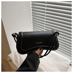 Detail showing wavy flap texture and unique knotted rope handle of black shoulder bag