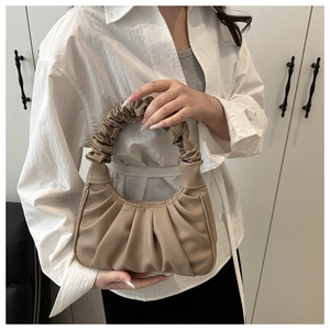 Dettaglio della borsa beige arricciata con design a pieghe e morbida pelle sintetica grana