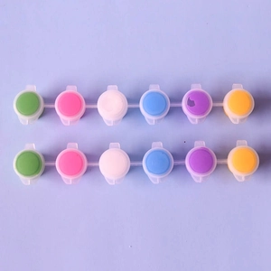 Detailed view of 6-color acrylic paint set in plastic pods with a soft purple background