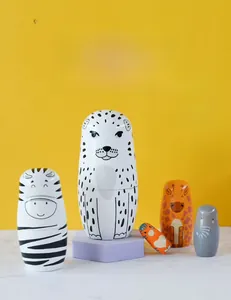 Detail of five-layer leopard and zebra nesting dolls on a purple geometric pedestal