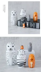 Detailed set of 5 hand-painted wooden animal nesting dolls on marble surface