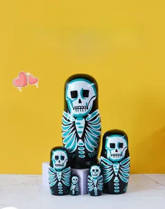 Set of five skull-themed nesting dolls with painted bones on black wood surfaces