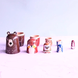 Handcrafted wooden nesting dolls featuring brown bear, fox and owl animal designs