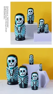 Detail of five-piece wooden nesting dolls with gothic skull design on yellow backdrop