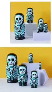 Detail of five-piece wooden nesting dolls with gothic skull design on yellow backdrop