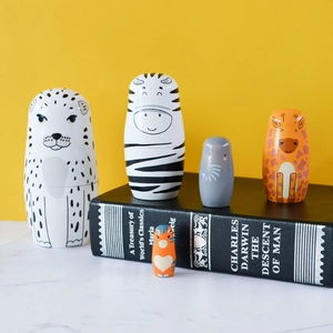 Handcrafted wooden Russian nesting dolls featuring hand-painted snow leopard and wild animals