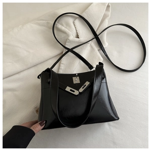 Detail of black vintage leather handbag featuring silver metal twist lock and texture