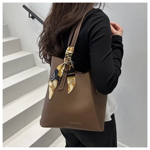 Detail of dark brown leather tote bag with vintage printed silk scarf on the handle