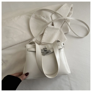 Detail of vintage white leather tote bag with classic metal twist lock and texture
