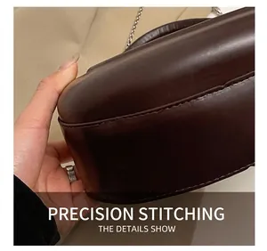 Detail shot of the precise stitching on the bottom of a vintage brown leather handbag