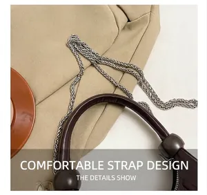 Detail of premium brown leather handle and fine silver chain strap on a crescent bag