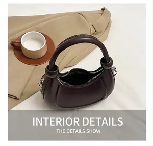 Deep brown crescent bag interior view showing storage space and metal zipper detail