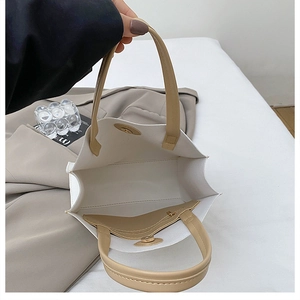 Top view of cream tote bag interior featuring a brown zipper pocket and magnetic closure