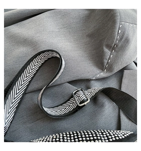 Close-up of stylish rhinestone crossbody bag with black and white chevron fabric strap
