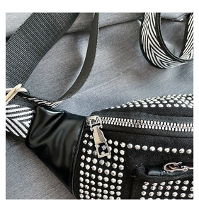 Detail of black rhinestone chest bag with silver zipper and geometric wide shoulder strap