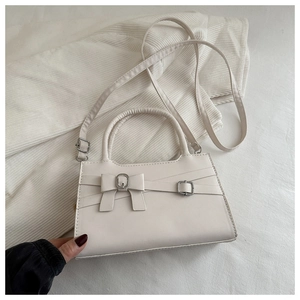Détail du sac à bandoulière vintage blanc avec nœud chic et ferrures métalliques