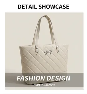 Close-up of beige quilted tote bag showing silver bow hardware and fine stitching detail
