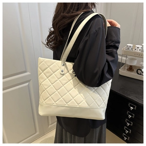Detail of quilted beige tote bag with large capacity and thick base for daily commuting