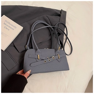 Detail of grey-blue textured shoulder bag with gold buckle on a stylish suit