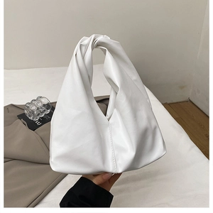 Detailed view of white pleated cloud bag with knotted handle and soft leather texture