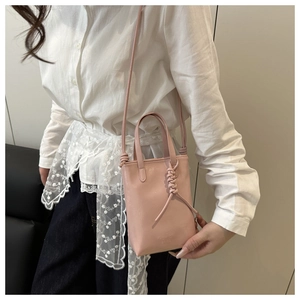 Détail du mini sac rectangulaire rose avec poignée tressée et bandoulière réglable