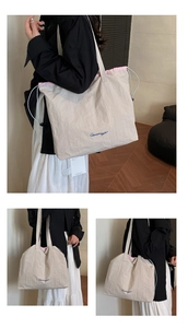 Détail d'un grand sac cabas beige avec cordon rose contrasté et broderie Qiwangfi élégante