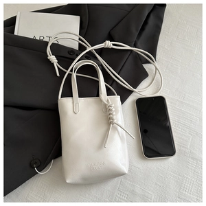 Detail of the white PU leather crossbody bag with braided rope handle and text engraving