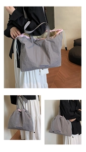 Détail du cabas en nylon gris montrant la doublure rose, le cordon et la broderie