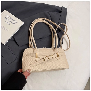 Close-up of beige woven texture pillow bag with gold hardware and top handles