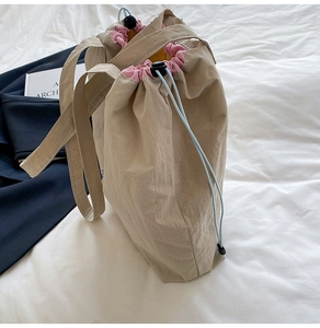 Détail du sac cabas beige à cordon avec bord plissé rose et cordon de serrage bleu
