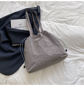 Détail du sac fourre-tout en nylon plissé gris avec cordon de serrage bleu clair