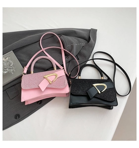 Detail of glitter flap and large gold D-ring buckle on minimalist shoulder bags