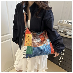Detail showing ethnic style patchwork shoulder bag with colorful embroidery and wide strap