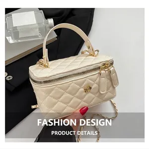 Detailed view of beige quilted vanity bag with golden camellia buckle and chain strap