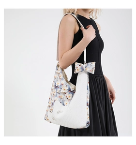 Floral patchwork tote bag with pearl accents and bow detail on female model