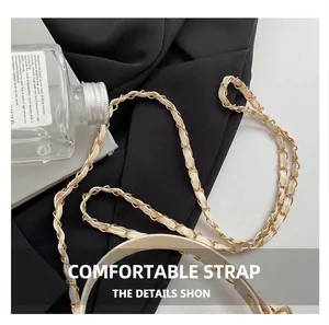 Close-up of beige quilted leather interwoven with a gold metal chain strap for handbags